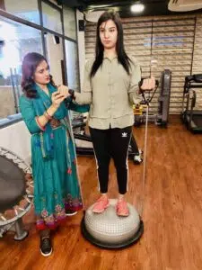 Dr. Tazia Sardar guiding a patient through a medically supervised personal training and balance stabilization session on a Bosu ball at Back in Motion in Gulshan-1, Dhaka.