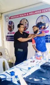 Dr. Md. Abdullah Yousuf performing a musculoskeletal shoulder assessment and mobility check on a patient during a Back in Motion public medical camp.